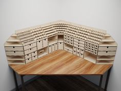 a wooden model of a building on top of a table with drawers and shelves in the middle