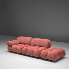 a pink couch sitting on top of a white floor