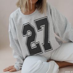 Custom Football Jersey Number Sweatshirt If you have any questions, or don't see exactly what you're looking for, reach out :)  ❣︎ Shop other variations of the product! ❥ Tshirt: https://babystee.etsy.com/listing/1823131895 ❥ Baby Tee: https://babystee.etsy.com/listing/1786023387 ❥ Boxy Tee: https://babystee.etsy.com/listing/1807313144 ✺ Made with a cozy blend of 50% cotton and 50% polyester, our medium-weight sweatshirt is your go-to for those chilly months <3 ✺ ❁ Sustainably made! Crafted from College Sweatshirt Outfit, College Football Tailgate, Number Graphic, Outfit College, Football Tailgate, Preppy Clothes, Y2k Preppy, Custom Football, Boxy Tee