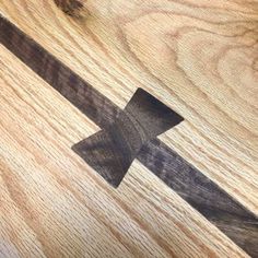 a close up of a wooden floor with an arrow cut in to it's center