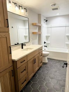 a bathroom with hexagonal tile flooring and wooden cabinets