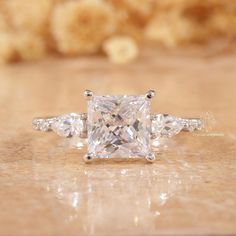 a princess cut diamond ring with three side stones