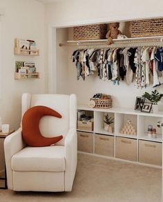 a white chair sitting in front of a closet filled with baby clothes and other items