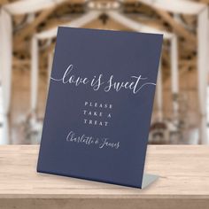 a card with the words love is sweet on it sitting on top of a wooden table