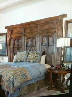 a bedroom with a large wooden headboard next to a night stand