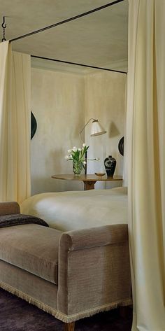 a large bed sitting under a canopy in a bedroom