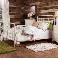 a white bed sitting in a bedroom next to a wooden wall covered in wood planks