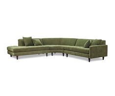 a green sectional couch with pillows on the bottom and back ends, sitting in front of a white background