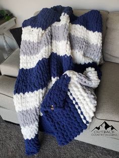 a blue and white blanket sitting on top of a couch