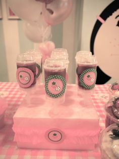 a pink table topped with cups filled with liquid