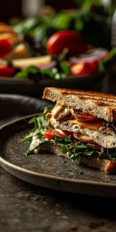 a grilled sandwich with lettuce, tomato and chicken on it sitting on a plate