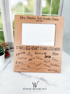 a wooden frame with writing on it and a potted plant in the back ground