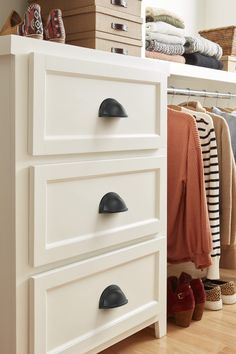 an organized closet with white drawers and black pulls on the bottom drawer, shoes are in the foreground