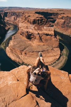 a woman climbing up the side of a cliff