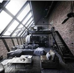 a living room filled with lots of furniture next to a staircase leading up to a loft