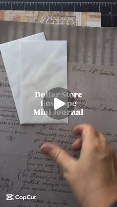 someone is pointing to an envelope on top of a piece of paper