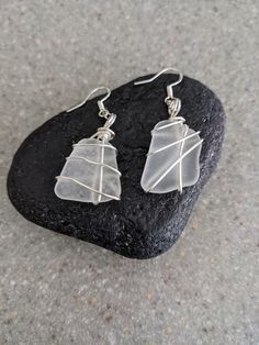 Wire Wrapped White Frosted Beach Glass Earrings These beautiful earrings are from Lake Michigan! They are authentic, white frosted glass and each piece is paired with 20 gage artistic wire wrap. The earrings are sterling and come with pushback closures. Imagine these sparkling pieces of beach glass started out as tossed used bottles  in to Lake Michigan. They naturally tumbled in the lake and washed back up as beautifully shaped frosted glass. They are a wonderful gift for the beach girl, birthd White Minimalist Glass Jewelry, Nickel-free White Glass Jewelry, Handmade White Glass Earrings, White Glass Earrings With Ear Wire, Adjustable Nickel-free White Crystal Earrings, Glass Dangle Earrings For The Beach, Clear Glass Jewelry For Beach, Adjustable White Wrap Earrings With Ear Wire, White Wire-wrapped Drop Crystal Earrings