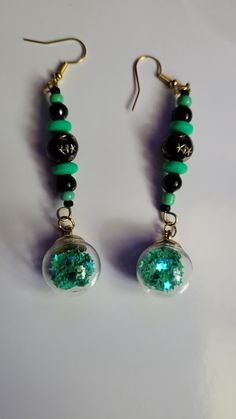 Green orb handcrafted earrings, with black and green beading Unique Green Beaded Dangling Earrings, Black Beaded Earrings With Ear Wire For Gift, Green Beaded Earrings With Round Beads, Nickel-free Green Beaded Earrings For Parties, Black Beads Dangle Earrings Gift, Black Beaded Dangle Earrings For Gifts, Black Resin Drop Earrings, Black Beaded Dangle Earrings Gift, Green Jewelry With Black Round Beads