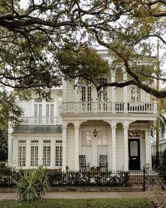 a large white house with lots of windows and balconies