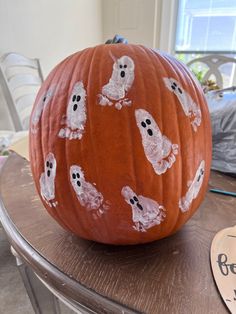 a pumpkin decorated with ghost faces on it