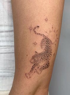 a cheetah tattoo on the side of a woman's lower leg is shown