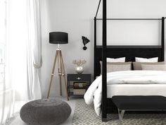 a bedroom with white walls and black furniture