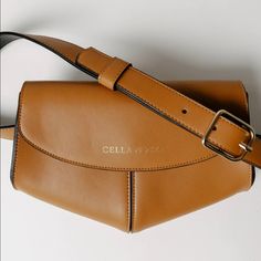 A Chic Accessory For The Woman On-The-Go. The Tan Belt Bag Is An Elegant And Pretty Fanny Pack, In A Modern And Compact Form. It Is The Perfect Size To Fit Your Phone, Wallet And Keys. Its Adjustable Waist Belt Strap Enhance Both Its Modern Feel And Its Practicality, As It Can Be Worn Around The Waist When With Kids On The Go. Details: Leather Exterior 8" Length X 6.5" Height X 4" Depth Removable And Adjustable Belt - Can Be A Clutch Or Belt Bag. Rectangular Leather Belt Bag For Shopping, Elegant Belt Bag With Removable Pouch For Shopping, Leather Belt Bag With Removable Pouch For Shopping, Gold Leather Crossbody Belt Bag, Brown Belt Bag With Gold-tone Hardware, Chic Gold Belt Bag For Everyday, Cognac Bag With Magnetic Closure For Everyday Use, Cognac Shoulder Bag With Magnetic Closure, Cognac Bag With Magnetic Closure