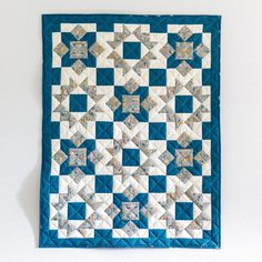 a blue and white quilt hanging on the wall