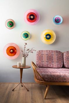 a couch and table in a room with colorful circles on the wall