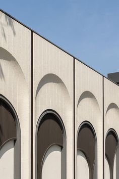 the building has arches and arched doors on it's sides, along with palm trees