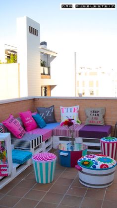 colorful cushions and pillows are arranged on the balcony