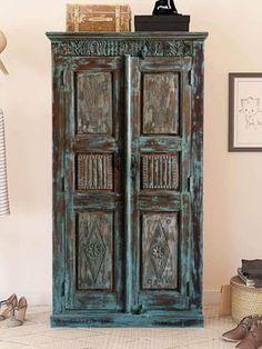 an old wooden armoire in a room with shoes on the floor and other items