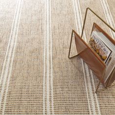 an open magazine holder sitting on top of a carpeted floor next to a book