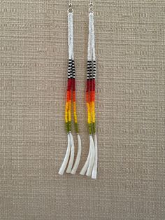 two pairs of earrings with multicolored tassels hanging from silver ear wires