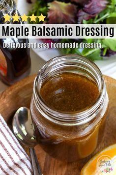 a jar of homemade maple balsamic dressing on a wooden plate with a spoon