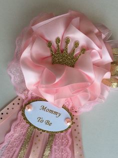 a pink flower with a gold crown on it's head and the words mommy to be written on it