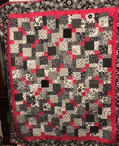 a black and white quilt with red accents