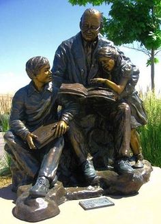 a bronze statue of two people reading a book