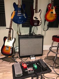 guitars and amps are lined up on the floor in front of a guitar amplifier