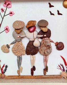 an image of three people in the middle of a frame with rocks and flowers on it