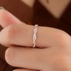 a woman's hand with a diamond ring on top of her finger and the band is