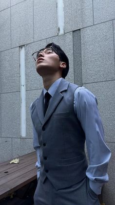 a man in a suit and tie standing next to a table with his eyes closed