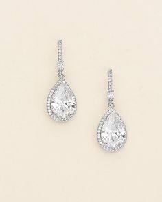 pair of white gold and diamond earrings with pear shaped diamonds on each earring side by side