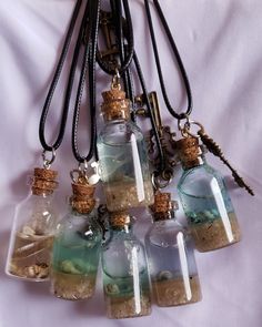 This ocean scenery bottle necklace features mini glass bottles with a blend of water, sand, seashells and resin, artfully arranged to create a breathtaking underwater seascape. The captivating design makes a unique statement piece, ideal for any beach or ocean-inspired outfit. Beach Sand Necklace, Mini Glass Bottle Necklace, Sand And Seashells In Jar, Sand Jars From Vacation, Ocean Themed Accessories, Seashell Resin Art, Beach Sand Crafts, Ocean In A Bottle, Underwater Seascape