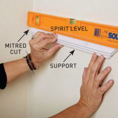 a person is measuring the wall with a spirit level and other parts to measure it