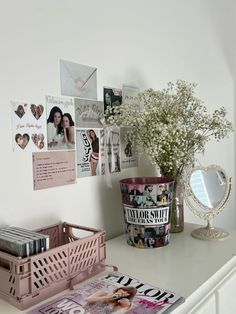 a white dresser topped with a vase filled with baby's breath next to a mirror