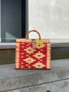 a red and white bag sitting on top of a cement wall next to a door