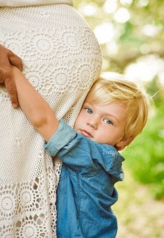 a little boy is holding his mother's belly