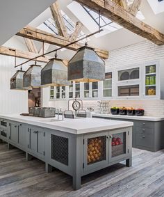 a large kitchen with an island and lots of lights hanging from it's ceiling