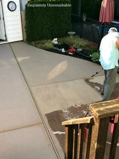 a man is using a pressure washer to clean the concrete in front of his house